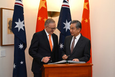 Australian Prime Minister Anthony Albanese looks on as Chinese Foreign
Minister Wang Yi signs the visitors' book on March 20, 2024, during a meeting at Parliament House in Canberra, Australia.
