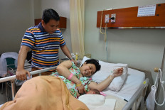Herber Anggara Pandapotan (left) visits on May 11, 2020  his wife Gresie Elfin Siahaan and their newborn baby girl, Bellvania Magdalena Sianturi, at Tambak Maternity and Children’s Hospital in Menteng, Central Jakarta.