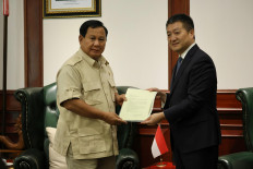 Defense Minister Prabowo Subianto (left) and Chinese Ambassador to Jakarta Lu Kang hold a cable sent by Chinese President Xi Jinping congratulating Prabowo on his presidential victory win in Jakarta on March 21, 2024.