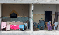 A woman sits on the terrace of her destroyed home on March 22, 2024 in Rafah, the southern Gaza Strip.