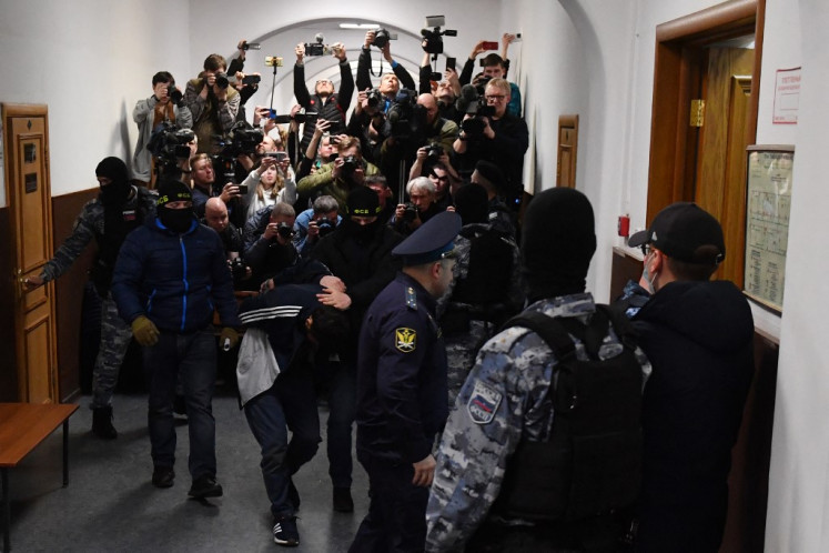 A man suspected of taking part in the attack of a concert hall that killed 137 people, the deadliest attack in Europe to have been claimed by the Islamic State jihadist group, is escorted by Russian law enforcement officers prior to his pre-trial detention hearing at the Basmanny District Court in Moscow on March 24, 2024. 