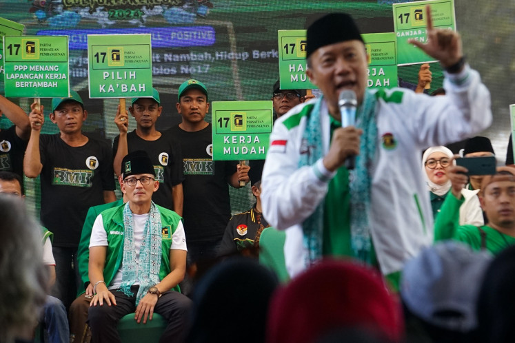 United Development Party's (PPP) election campaign team head Sandiaga Salahuddin Uno (left) sits when a party's legislative candidate Agoes Joesni (right) talks with voters during a campaign rally event in Pekalongan, Central Java on Feb. 4, 2024.
