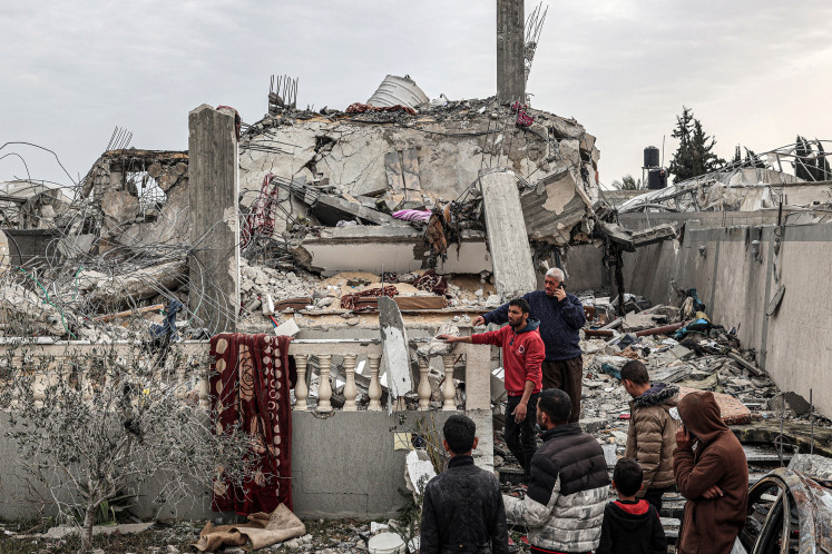 People inspect damage to a building that was hit overnight during Israeli bombardment in Rafah in the southern Gaza Strip on March 26, 2024, amid the ongoing conflict in the Palestinian territory between Israel and the militant group Hamas.
