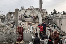 People inspect damage to a building in Rafah in the southern Gaza Strip on March 26, 2024, after it was hit overnight during Israeli bombardment, amid the ongoing conflict between Israel and the militant group Hamas.