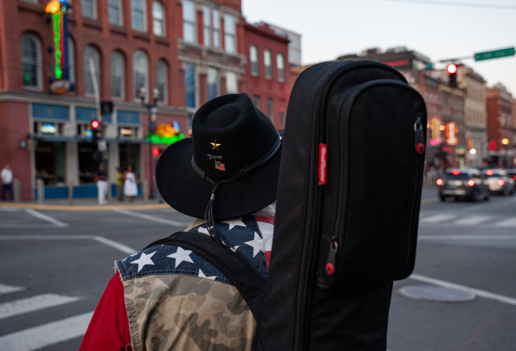 A musician walks with his guitar on Broadway in Downtown Nashville on March 13, 2024 in Nashville, Tennessee in the United States. Megastar Beyonce's highly anticipated country album, out on March 29, 2024, has cast a spotlight on efforts by Black performers – a vital part of the genre's history – to create a more inclusive Nashville.