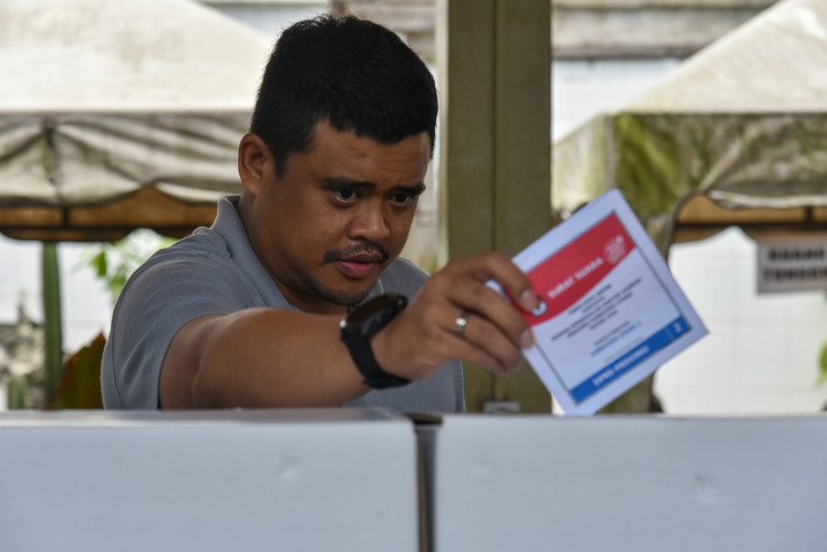 Medan Mayor Bobby Nasution inserts his 2024 election ballot paper into a ballot box on Feb. 14, 2024, at a polling station in Medan, North Sumatra.
