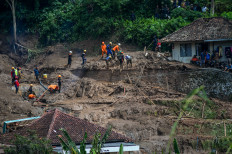 Search-and-rescue officials comb through the site of a landslide in Cibenda village, West Java on March 25, 2024 in search of survivors. Data from the local disaster mitigation agency suggests 10 people remain missing after the village became inundated the night before.