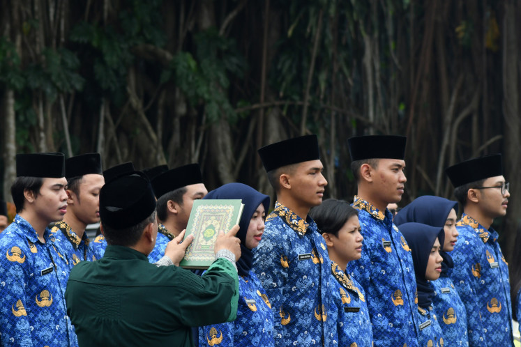 New civil servants take their oath on March 22, 2024 during an induction ceremony at Bogor City Hall in Bogor, West Java.