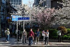 People walk on a street in the Huangpu district, in Shanghai, China, on March 30, 2024. 