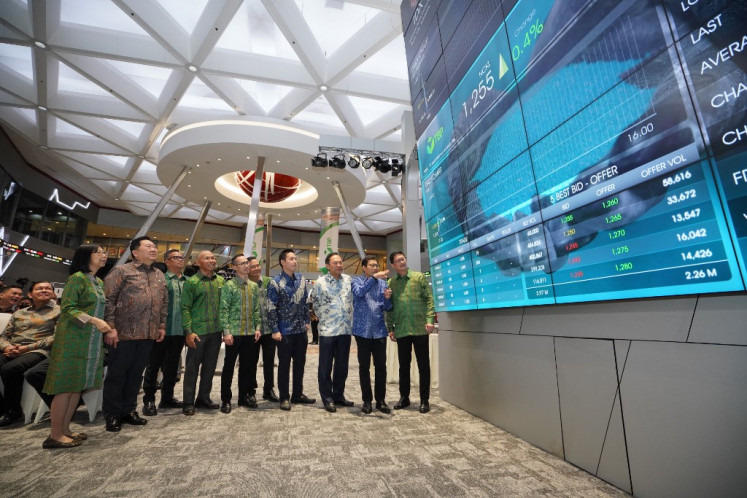 Roy Arman Arfandy (right), president director of PT Trimegah Bangun Persada (NCKL), the nickel subsidiary of Harita Group, stands along with members of its board of directors on April 12, 2023 to view an electronic display showing its shares during its initial public offering (IPO) at the Indonesia Stock Exchange (IDX) in Jakarta.
