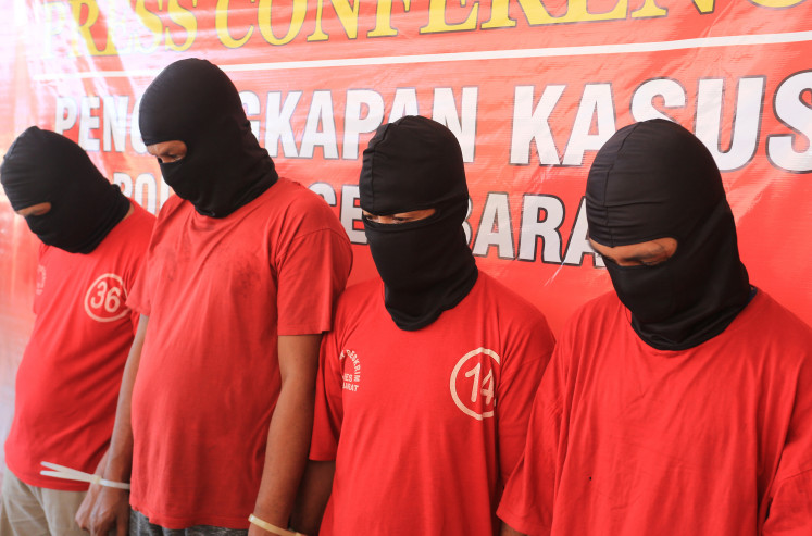 Four human-trafficking suspects are presented during a press conference on April 2, 2024, at West Aceh Police headquarters, Aceh. Police say they are still hunting down another four people suspected of trafficking Rohingya refugees.