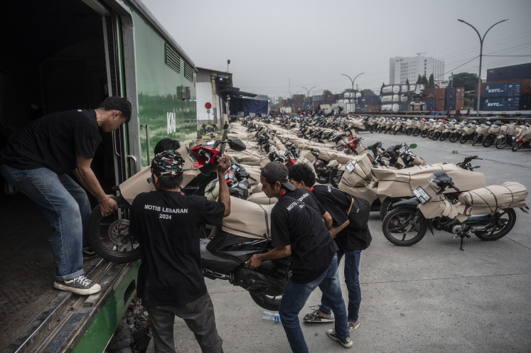 Workers load a motorcycle onto a train on April 3, 2024, at Jakarta Gudang Station. The Transportation Ministry provided free shipment for 12,180 motorbikes ahead of the Idul Fitri holiday from April 2-8 and after the holiday from April 13-19.