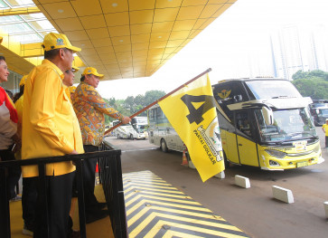 Golkar Party chairman Airlangga Hartarto (right) waves the party flag at its headquarters in Jakarta on April 3, 2024, to mark the departure of a free Idul Fitri mudik (exodus) trip it sponsored.