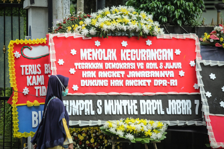 A pedestrian walks along a row of flower board in front of the headquarters of the Indonesian Democratic Party of Struggle (PDI-P) in Jakarta on March 8, 2024. The party office is swarmed by flower boards declaring support for the party to pursue a legislative inquiry into alleged irregularities in the 2024 general election at the House of Representatives.