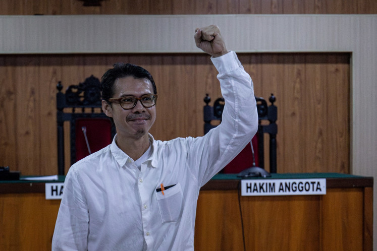 Environmental activist Daniel Frits Maurits Tangkilisan greets his supporters ahead of his verdict hearing at the Jepara District Court in Jepara, Central Java on April 4, 2024. A panel of judges finds him guilty of defamation for his Facebook post pertaining to the pollution from shrimp farms in Karimunjawa Islands in Central Java, punishing him with seven months of imprisonment and a Rp 5 million (US$315) fine.