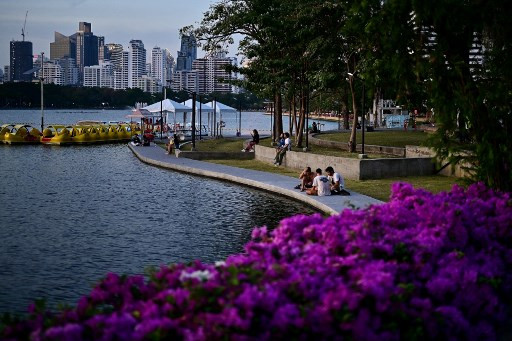 People sit by the lake at Benchakitti Park in Bangkok on March 5, 2024.