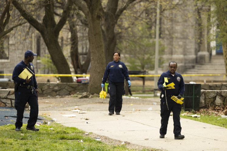 Members of the crime scene unit marks shell casings after a shooting in Clara Muhammad Square during an Eid al-Fitr celebration in Philadelphia, Pennsylvania, United States, on Wednesday, April 10, 2024. Three people were wounded in a shootout during an Eid celebration in Philadelphia, a major city on the US east coast, police said, referring to “two factions“ who exchanged gunfire in a park.