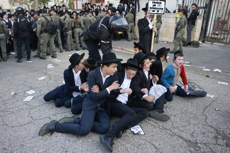 Israeli police disperse Ultra-Orthodox Jewish men and youth during a protest against Israeli army conscription outside an army recruitment office in Jerusalem on April 11, 2024.
