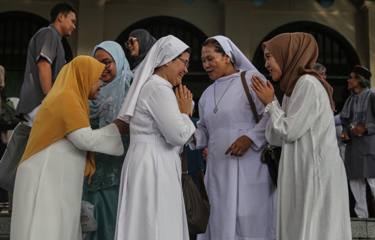 Muslim women greet their Christian colleagues during an interfaith event at the Grand Mosque of Central Java in Semarang, Central Java on April 10, 2024.