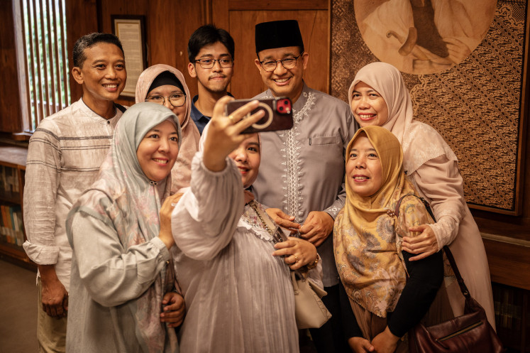 Former Jakarta governor Anies Baswedan (third right) poses for a group selfie during an open house event in Jakarta on April 10, 2024, to celebrate Idul Fitri, which marks the end of the holy month of Ramadan. Anies, who ran for president in the February election, is currently challenging the election returns in court.