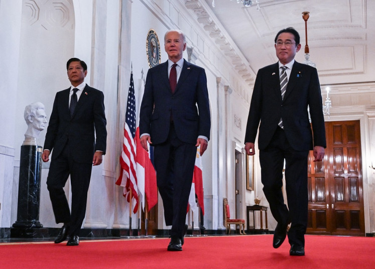 US President Joe Biden heads to a trilateral meeting with Japanese Prime Minister Fumio Kishida (right) and Filipino President Ferdinand Marcos Jr. (left) at the White House in Washington, DC, on April 11, 2024.