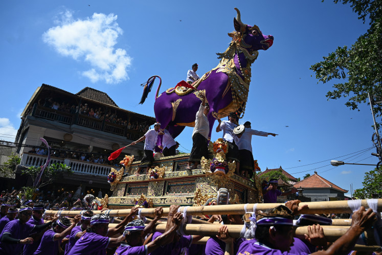 A sarcophagus depicting a purple cow is paraded on April 14, 2024,
in Ubud, Bali, during the cremation ceremony of Tjokorda Bagus Santaka, a member of the Ubud royal family who passed away in February 2024.