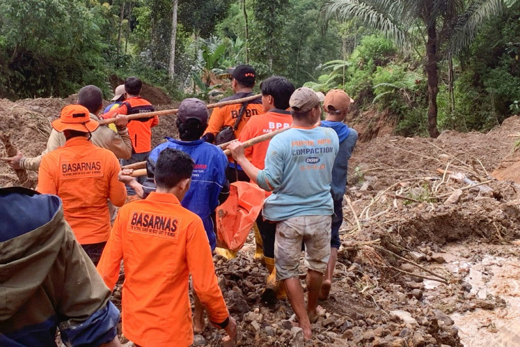 This handout photo released on April 14, 2024 by the National Search and Rescue Agency (BASARNAS) shows rescuers carrying a body bag at a landslide site in Tana Toraja, South Sulawesi. 