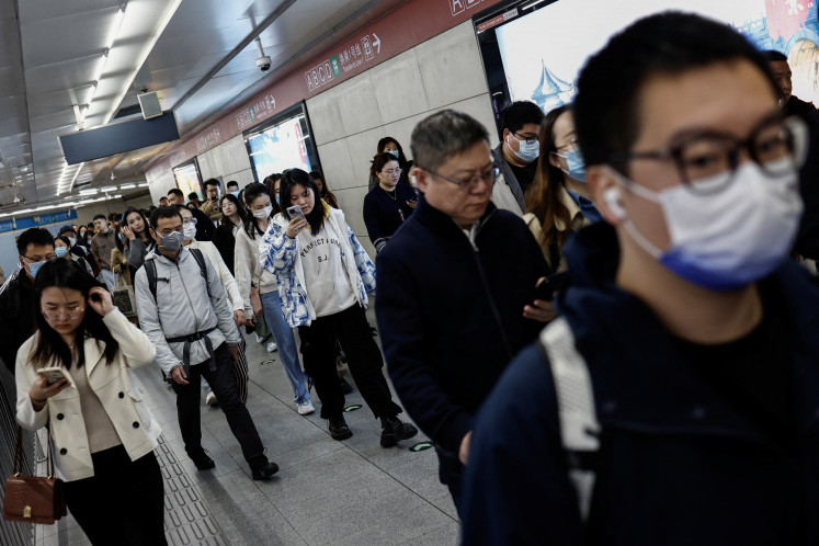 People walk at a subway station during morning rush hour in Beijing on April 11, 2024.
