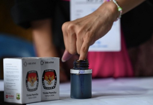 A voter inks her finger on Feb. 14, 2024, after casting her ballot in the 2024 general election in Banjar Teba, Jimbaran, Bali.
