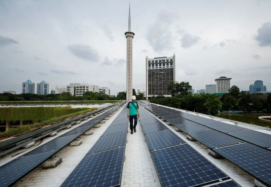 Faith in green energy: A technician walks on March 26, 2024, between solar panels that partially provide electrical power to Istiqlal Mosque in Jakarta. 