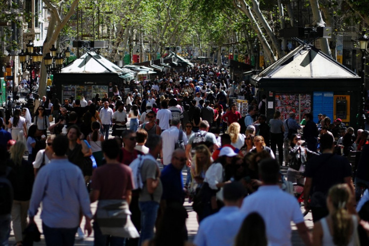 Tourist walk up and down Las Ramblas alley in Barcelona on April 13, 2024. From the Balearic Islands to the Canary Islands, Barcelona and Malaga, anti-mass tourism movements are multiplying in Spain. 