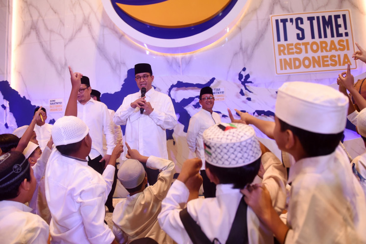 Presidential candidate and former Jakarta governor Anies Baswedan (center) greets children on March 22, 2024, during an iftar gathering at the NasDem Tower in Jakarta.