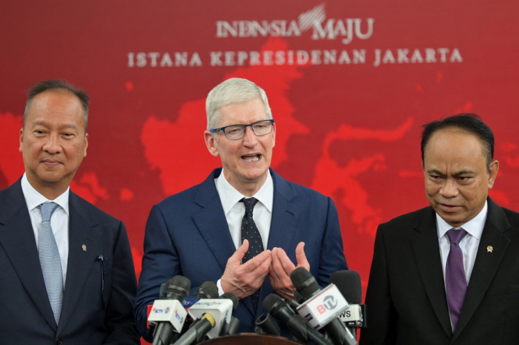 Industry Minister Agus Gumiwang Kartasasmita (left) and Communications and Information Minister Budi Arie Setiadi (right) flank Tim Cook as the Apple CEO addresses a press conference on April 17, 2024, following his meeting with President Joko “Jokowi“ Widodo at Merdeka Palace in Jakarta.