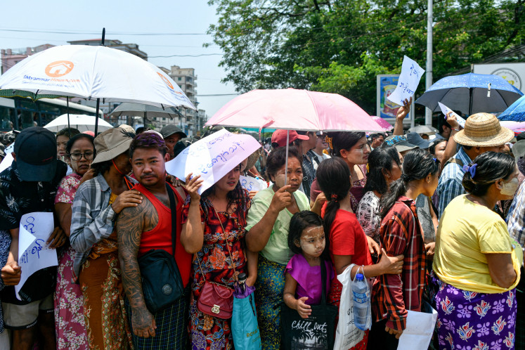 Relatives gather on April 17, 2024, around a bus carrying prisoners being released from Insein prison for the Buddhist New Year, in Yangon. 