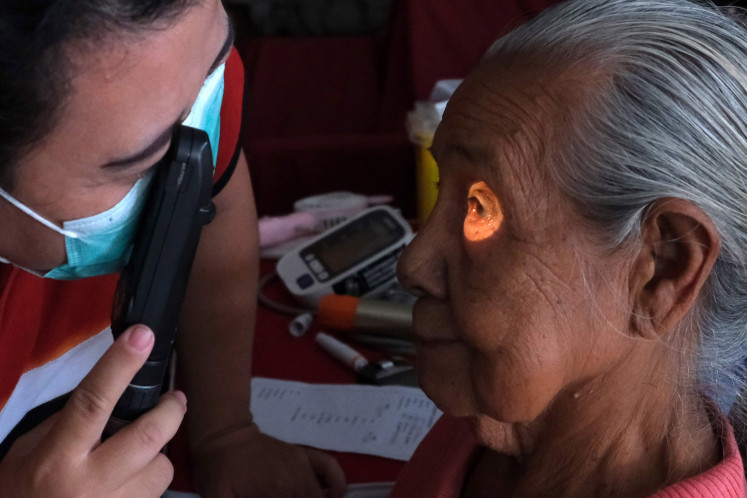 A doctor examines a patient on March 27, 2024, during a free public health screening in Dangin Puri Kauh village, Denpasar, Bali.