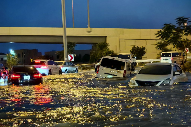 Cars drive in a flooded street following heavy rains in Dubai on April 17, 2024. Dubai, the Middle East's financial centre, has been paralysed by the torrential rain that caused floods across the UAE and Bahrain and left 18 dead in Oman on April 14 and 15. 
