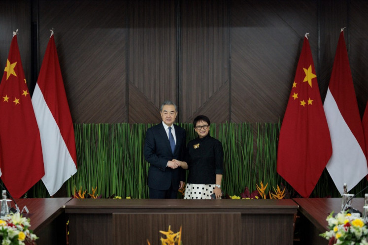China's Foreign Minister Wang Yi  (left) and Foreign Minister Retno Marsudi shake hands before their bilateral meeting at the Foreign Ministry office in Jakarta on April 18, 2024. 
