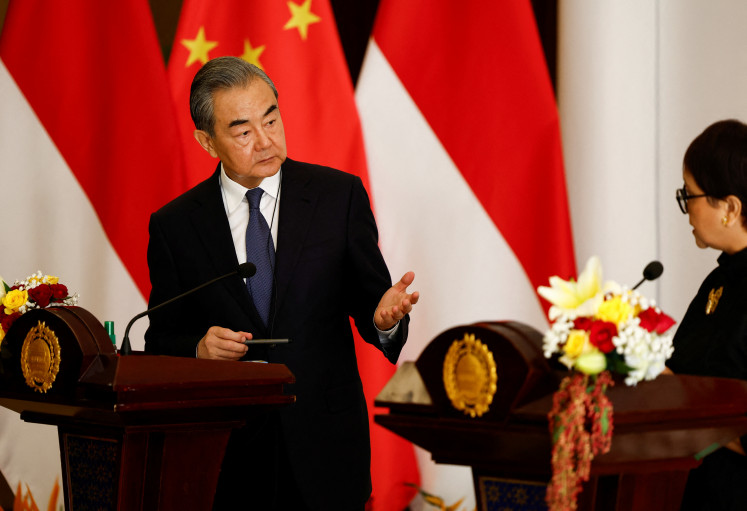 Chinese Foreign Minister Wang Yi gestures during a joint press conference with Foreign Minister Retno LP Marsudi following their bilateral meeting in Jakarta, on April 18, 2024.