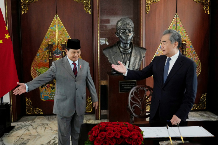 Defense minister and president-elect Prabowo Subianto shows the way to Chinese Foreign Minister Wang Yi after he signed the guest book during their meeting in Jakarta, on April 18, 2024. 