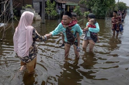 Wet celebration: Residents of Sayung village in Demak regency, Central Java, exchange Idul Fitri greetings on April 10, 2024 amid a flood that hit their neighborhood.