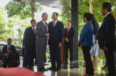 Chinese Foreign Minister Wang Yi (left) shakes hands with Coordinating Maritime Affairs and Investment Minister Luhut Pandjaitan (right) in Labuan Bajo, Indonesia, on April 19, 2024.