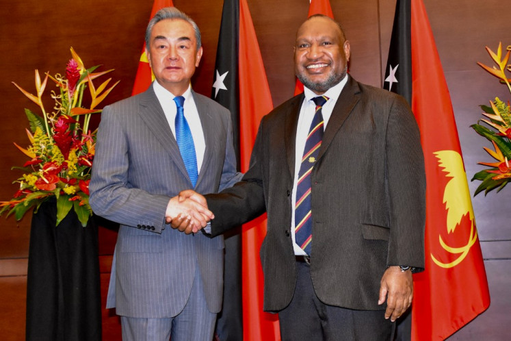 Papua New Guinea Prime Minister James Marape shakes hands with China Foreign Minister Wang Yi in Port Moresby on April 21, 2024.