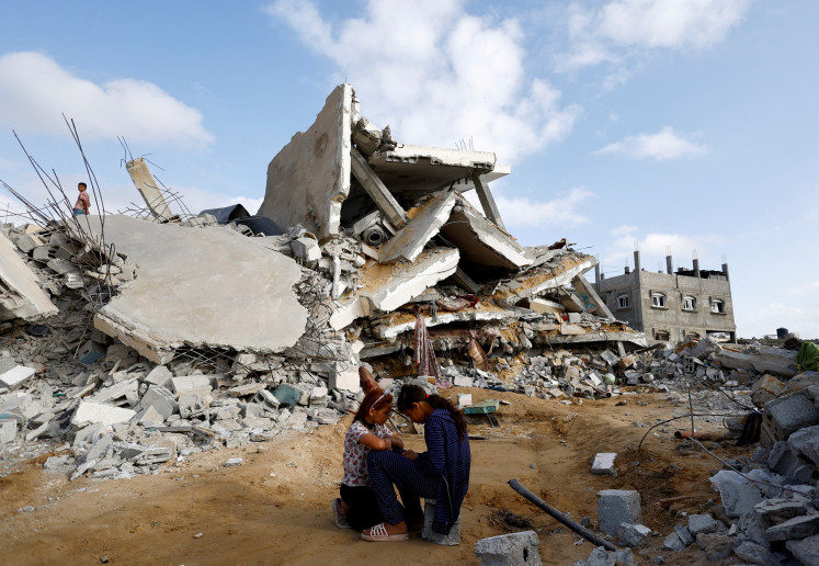 Dangerous playground: Palestinian children sit on April 21, 2024, next to the site of an Israeli strike on a house, amid the ongoing conflict between Israel and the Palestinian Islamist group Hamas, in Rafah, in the southern Gaza Strip.
