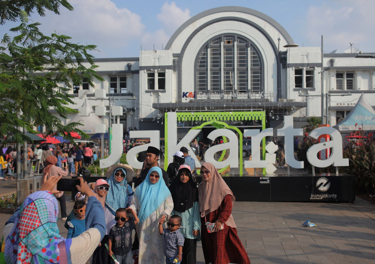 Tourists pose for a photo in Jakarta's Kota Tua on April 16, 2024.