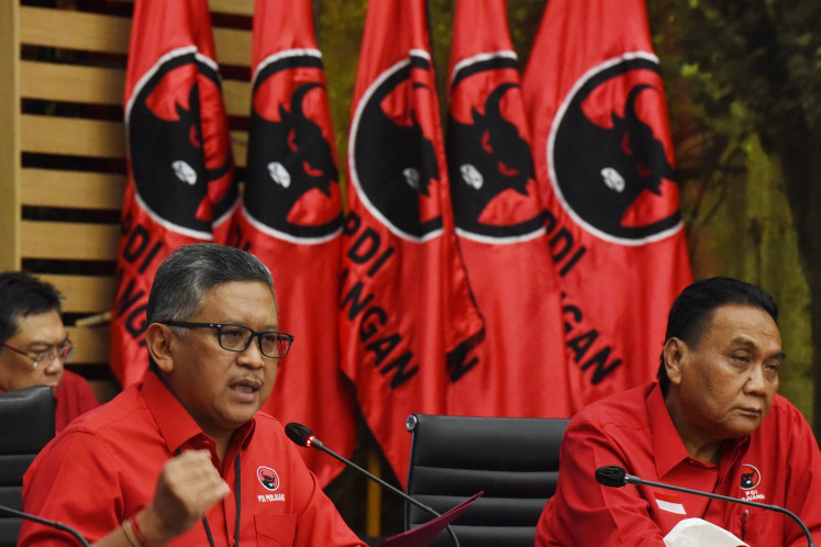 Indonesian Democratic Party of Struggle (PDI-P) secretary-general Hasto Kristiyanto (left), accompanied by the party's campaign team head Bambang Wuryanto (right), speaks to reporters during a press briefing at the party's headquarters in Jakarta on April 22, 2024.
