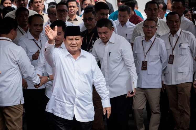 President-elect Prabowo Subianto waves to the media on April 24, 2024, as he arrives at the plenary session of the General Elections Commission (KPU) after challenges to his election victory were rejected, at the KPU office in Jakarta. 