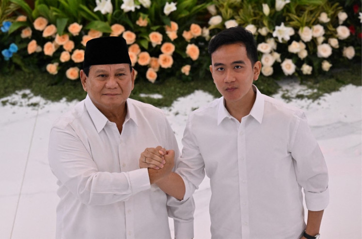 President-elect Prabowo Subianto (left) and vice president-elect Gibran Rakabuming Raka (right) wave to journalists on April 24, 2024, after the General Elections Commission (KPU) announced the 2024 presidential election results, in Jakarta.