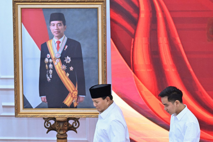 President-elect Prabowo Subianto (left) and vice president-elect Gibran Rakabuming Raka (right) walk past a portrait of President Joko “Jokowi“ Widodo, Gibran's father, during the plenary meeting of the General Elections Commission (KPU) announcing the 2024 presidential election winner in Jakarta on April 24, 2024.