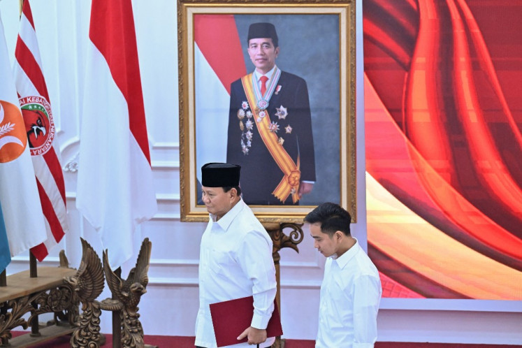President-elect Prabowo Subianto (left) and vice president-elect Gibran Rakabuming Raka (right) walk past a portrait of President Joko “Jokowi“ Widodo, Gibran's father, during a plenary meeting of the General Elections Commission (KPU) announcing the 2024 presidential election winner in Jakarta on April 24, 2024.