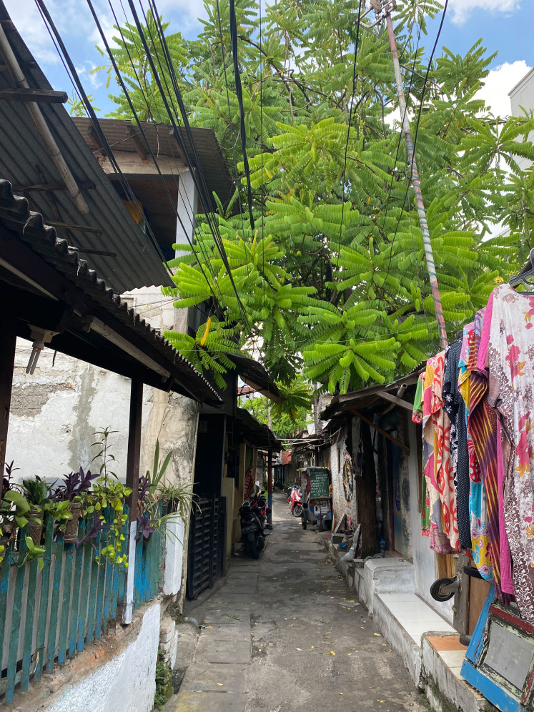 Alley amble: Colorful clothing are hung up to dry on April 15, 2023,  across ornamental plants decorating a fence along a small alleyway in Tebet, South Jakarta. (Courtesy of Harriet Crisp)